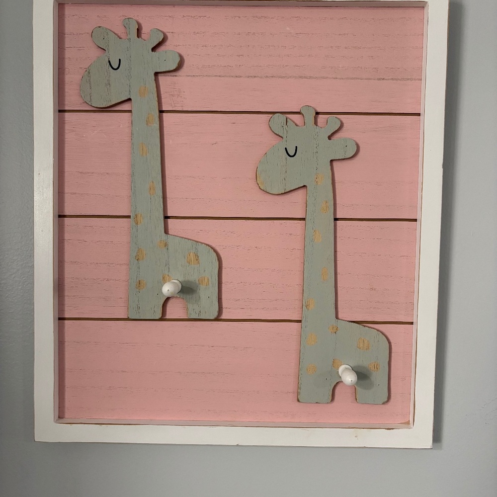 Adorable giraffe wooden distressed wall decor with knobs to hang items.